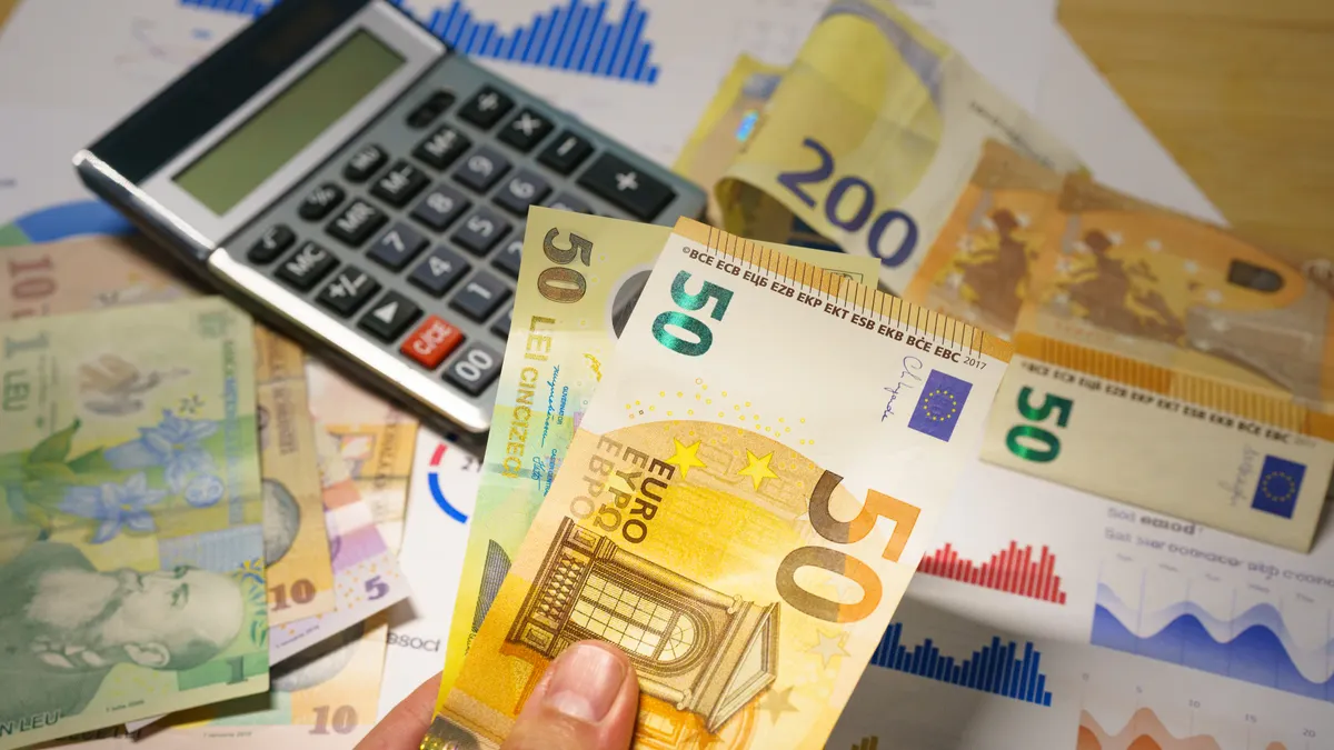Calculator with euro banknotes and financial charts