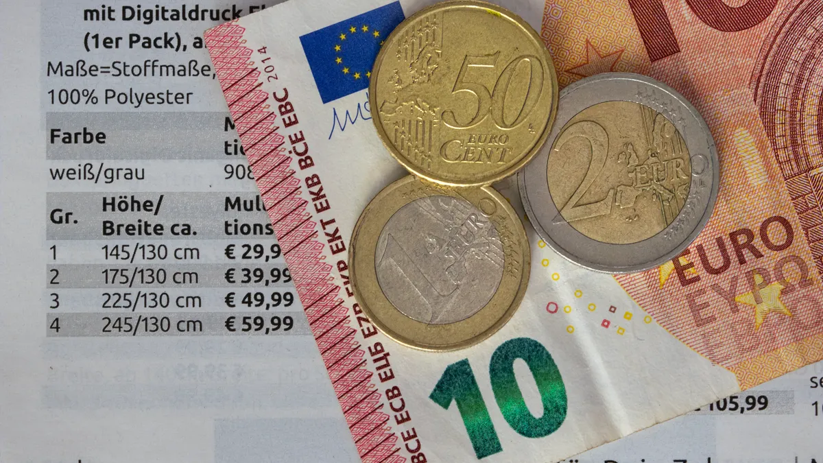 Euro coins and banknotes over a pricing sheet