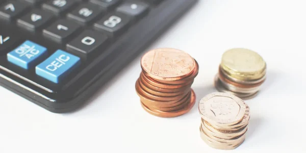 Calculator beside stacks of coins