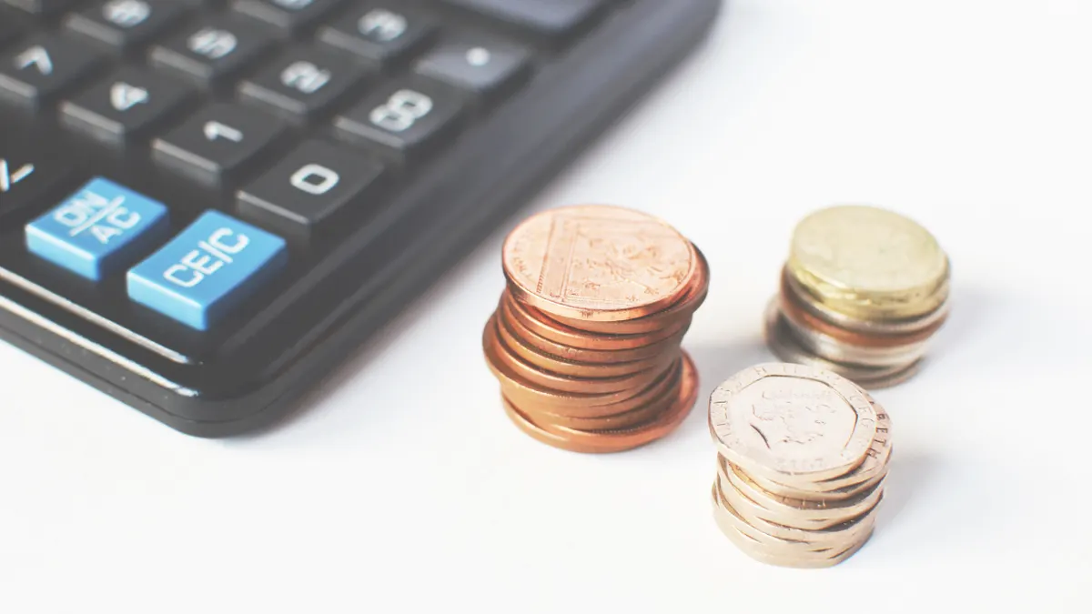 Calculator beside stacks of coins