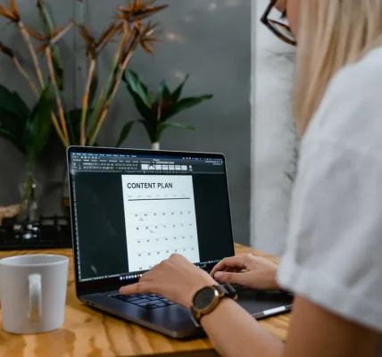 Person using laptop with a content plan on screen