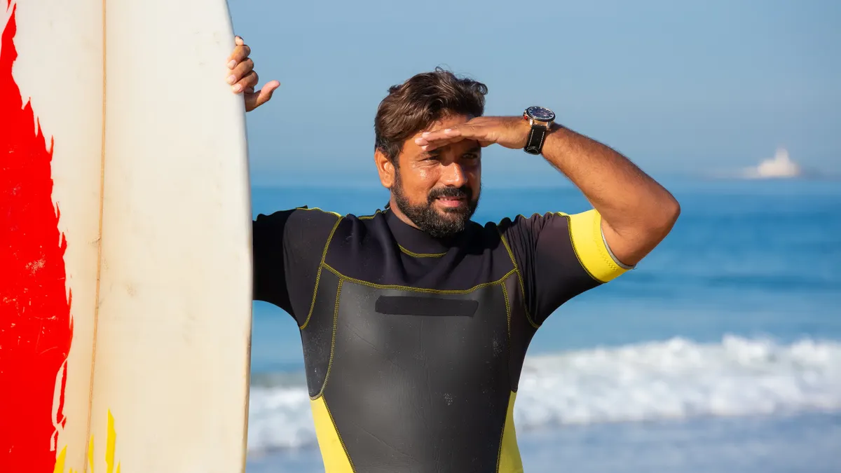 Surfer SEO review: how its content editor helps optimize pages for search — Content ethnic male surfer standing near sur