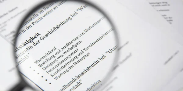 magnifying glass over a text document with bullet points
